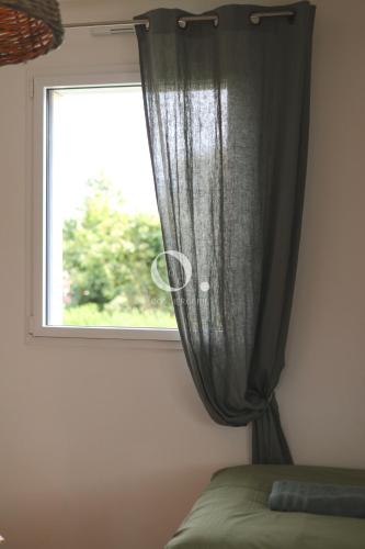 a window with a curtain in a bedroom at COC - Villa Parenthèse in Tardinghen