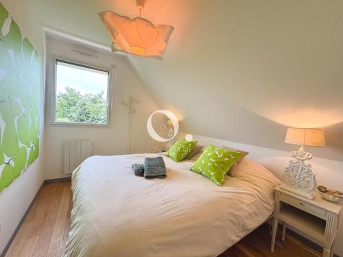 a bedroom with a bed with green pillows and a window at COC - Villa Parenthèse in Tardinghen