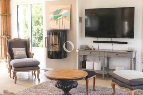 a living room with a tv and a table and chairs at COC - Villa Parenthèse in Tardinghen