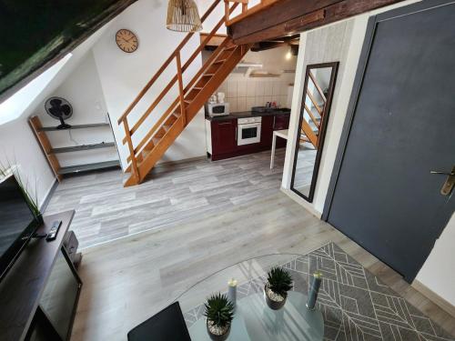 une vue aérienne d'un loft avec une cuisine et des escaliers dans l'établissement L'appartement d'Edmond Bour, à Gray