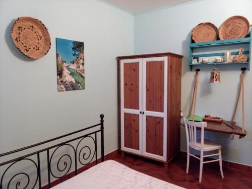 a bedroom with a bed and a cabinet and a table at Locanda D'Ogliastra, in Triei