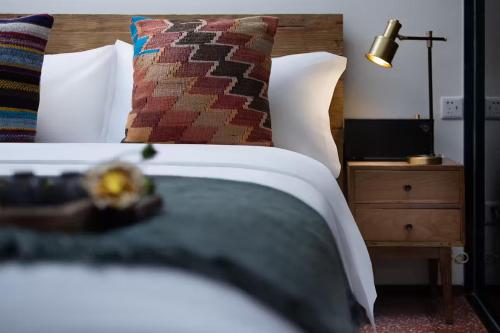 a bedroom with a bed and a lamp on a night stand at Peking Yard Boutique Hotel in Beijing