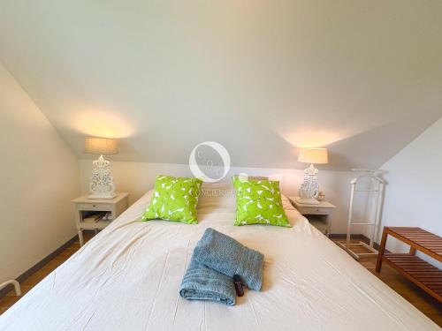 a white bed with green pillows and two lamps at COC - Villa Parenthèse in Tardinghen