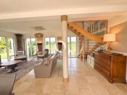 a living room with a spiral staircase in a house at COC - Villa Parenthèse in Tardinghen
