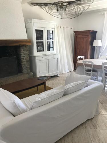 un salon avec un canapé blanc et une table dans l'établissement Le jardin de Dragey, à Dragey-Ronthon