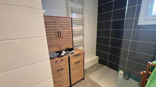a bathroom with a wooden cabinet and a shower at La Lémania in Messery