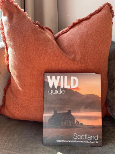 a book sitting on a couch next to two pillows at The Inverkip Restaurant, Bar & Hotel in Inverkip