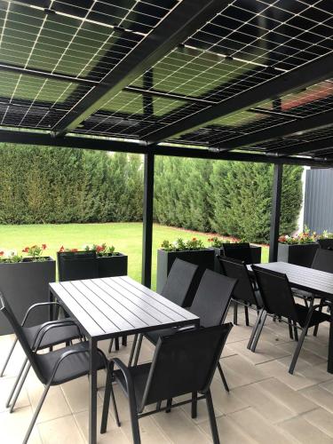 a group of tables and chairs on a patio at Theresa Vendégház in Kiskunmajsa