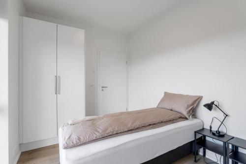 a bed in a room with white walls at 3BR Modern & Spacious Golden Circle Home in Reykholt