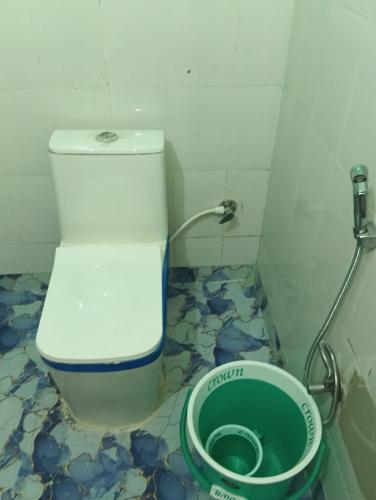 a bathroom with a toilet and a bucket at Jankivihar Homestay at Prahladghat within 1km from Shri Ram Mandir in Ayodhya