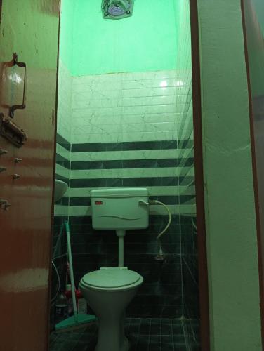 a bathroom with a white toilet in a room at Jankivihar Homestay at Prahladghat within 1km from Shri Ram Mandir in Ayodhya