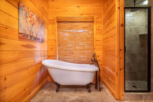 Cette chambre dispose de murs en bois et d'une baignoire. dans l'établissement Sunflower Summit By Avada Properties, à Sevierville