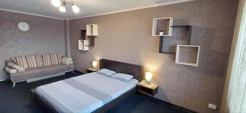 ein Schlafzimmer mit einem Bett und einer Couch in der Unterkunft Luxury apartment Slobozhansky Prospekt in Nizhnedneprovsk