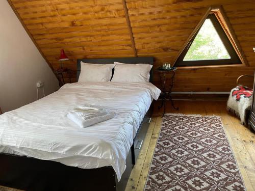 a large bed in a room with a window at Casa Rujoiu in Bertea