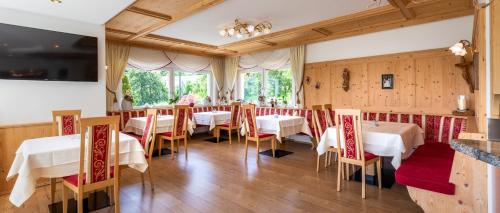 a restaurant with tables and chairs in a room at Passerblick in Tirolo