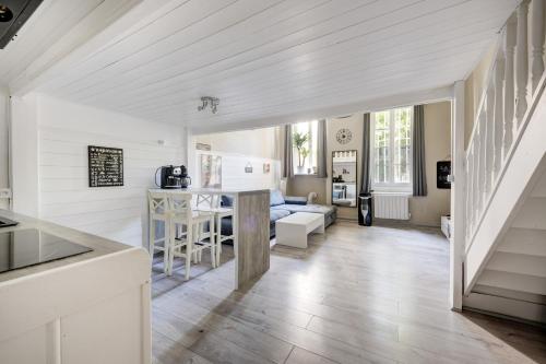 Il comprend une cuisine et un salon avec des murs blancs et du parquet. dans l'établissement « Le Vieux Lyon » 45 m2 tt équipé Clim, à Lyon