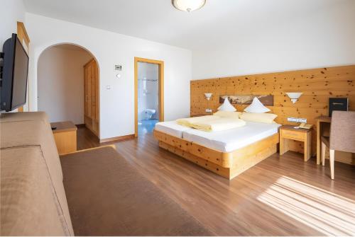 a bedroom with a large bed and a couch at Passerblick in Tirolo