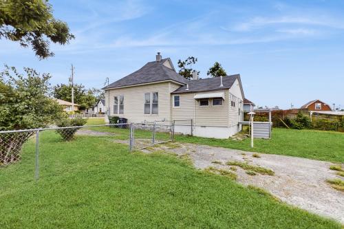 a house with a fence in front of a yard at The Rogers Roost in Rogers