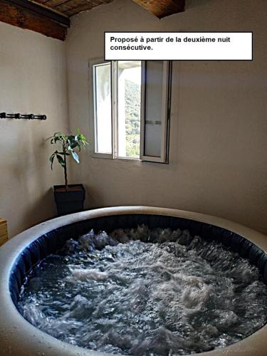 a large bath tub filled with water in a room at CROUXETO Chambres d'hôte in Duilhac