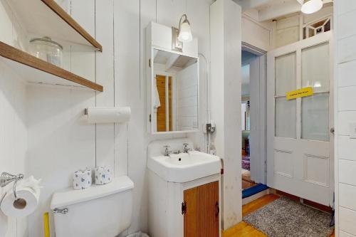 a bathroom with a toilet and a sink and a mirror at Beach House in Oak Bluffs