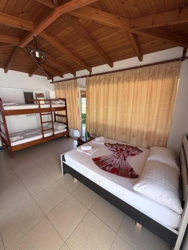 a bedroom with two bunk beds and a wooden ceiling at Denaj House in Himare