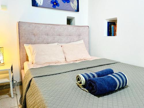 a bed with a blue towel laying on it at Chora Suite in Mikonos