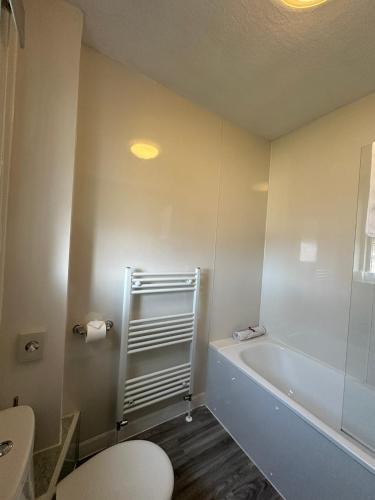 a bathroom with a tub and a toilet and a sink at Guisachan Guesthouse in Fort William
