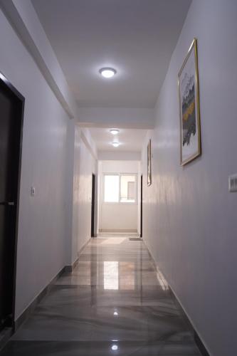 a hallway with white walls and a door with a window at Hotel Airport Stay in New Delhi