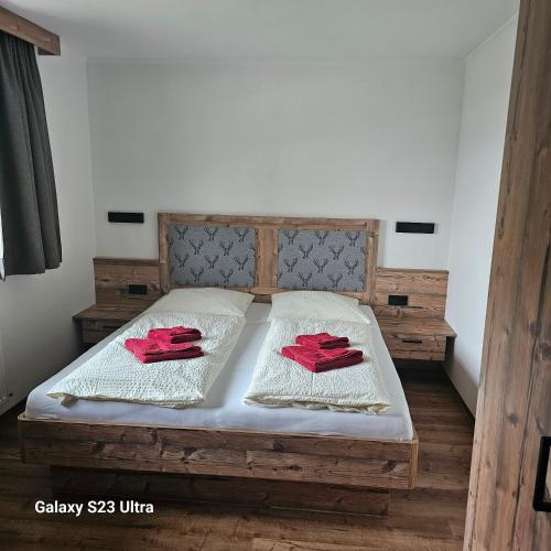 a bed with two red napkins on top of it at Appartementhaus Eisbauer in Sankt Johann im Pongau