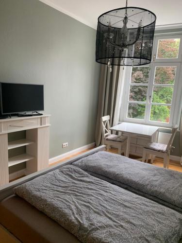 a bedroom with a bed and a desk and a television at Altes Forstamt in Xanten