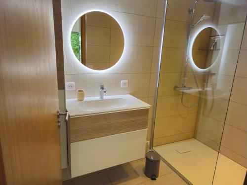 a bathroom with a sink and a shower with a mirror at Centre Juan Les Pins 2P White Pearl garage in Juan-les-Pins