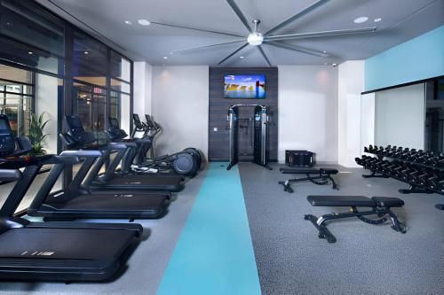 a gym with rows of treadmills and exercise bikes at Charming Condo with Nice Amenities at Alexandria in Alexandria