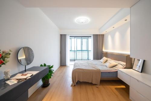 a bedroom with a bed and a desk with a mirror at EHUB - Super Luxury Apt at the Bund Area with Big Balcony, Surrounded by Shopping & Dining in Shanghai
