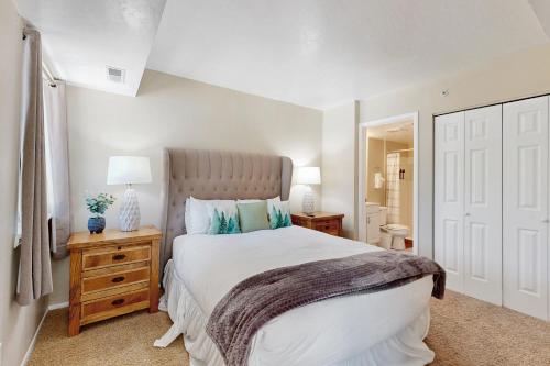 a bedroom with a large white bed and a night stand at New Claim Condominiums 114 in Park City