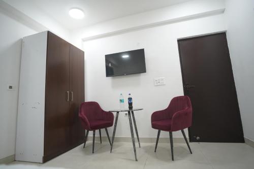 a room with a table and two red chairs at Hotel Airport Stay in New Delhi