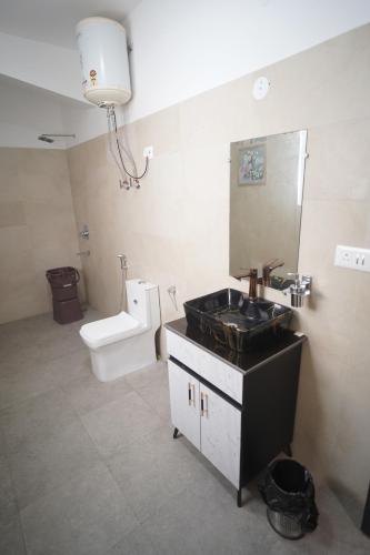 a bathroom with a sink and a toilet and a mirror at Hotel Airport Stay in New Delhi