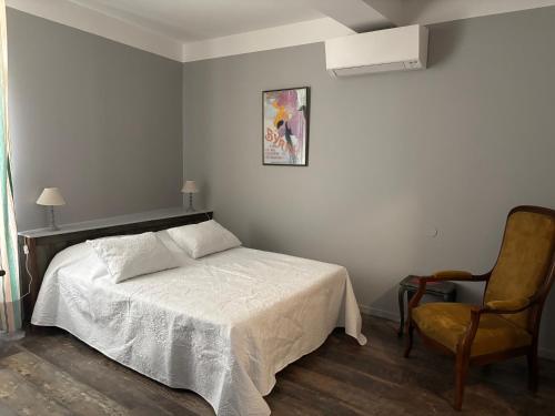 a bedroom with a bed and a chair at El Castell Embruixat in Saint-Hippolyte