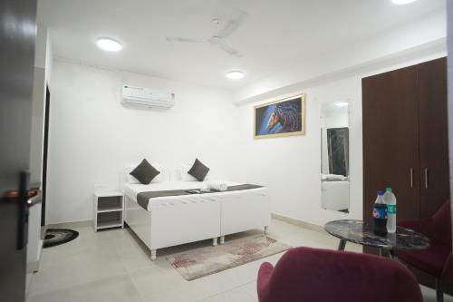 a white living room with a couch and a table at Hotel Airport Stay in New Delhi