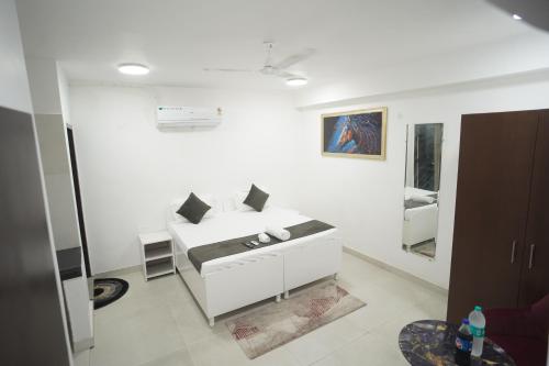 a white room with a bed and a mirror at Hotel Airport Stay in New Delhi