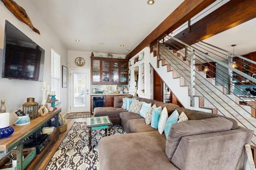 un soggiorno con un divano e una scala di Mermaid Manor a Fort Bragg