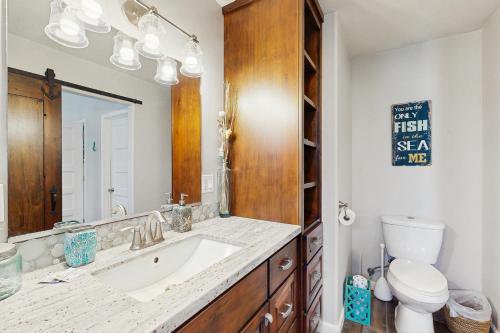un bagno con lavandino, WC e specchio di Mermaid Manor a Fort Bragg