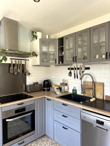 une cuisine avec des armoires blanches et un évier dans l'établissement Ocra Pure, à Roussillon