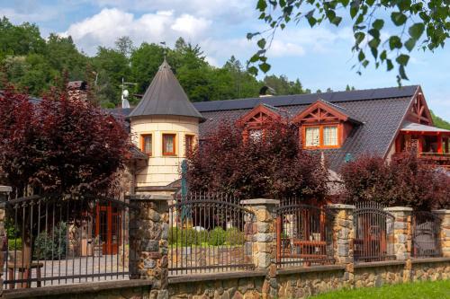 a house with a fence in front of it at Zámeček Kaliště in Poddubí