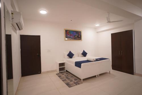 a white room with a bed and a painting on the wall at Hotel Airport Stay in New Delhi