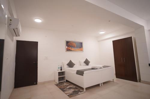 a white room with a bed and two doors at Hotel Airport Stay in New Delhi