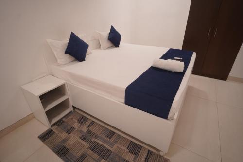 a white bed with blue pillows in a room at Hotel Airport Stay in New Delhi