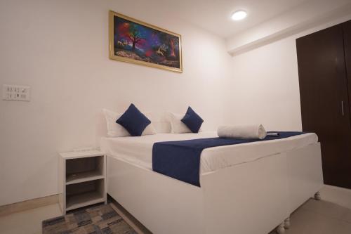 a white bedroom with a bed and a picture on the wall at Hotel Airport Stay in New Delhi