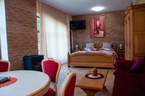 a bedroom with a bed and a table and chairs at Zámeček Kaliště in Poddubí