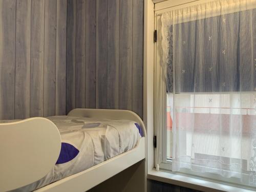 een kleine slaapkamer met een bed en een raam bij APARTAMENTO HENDAYA Playa-wifi-parking in Hendaye
