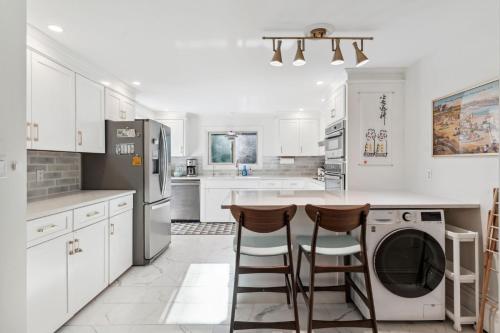 a kitchen with white cabinets and a washer and dryer at Washington's Rye House AC Bikes New Kitchen in Rye